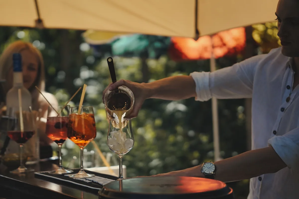 Ein Cocktail wird an der mobilen Bar von Roots & Liquor frisch eingeschenkt.